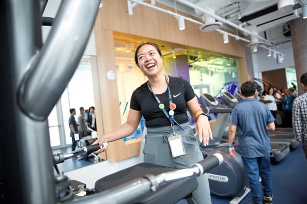 Woman demonstrating exercise equipment.