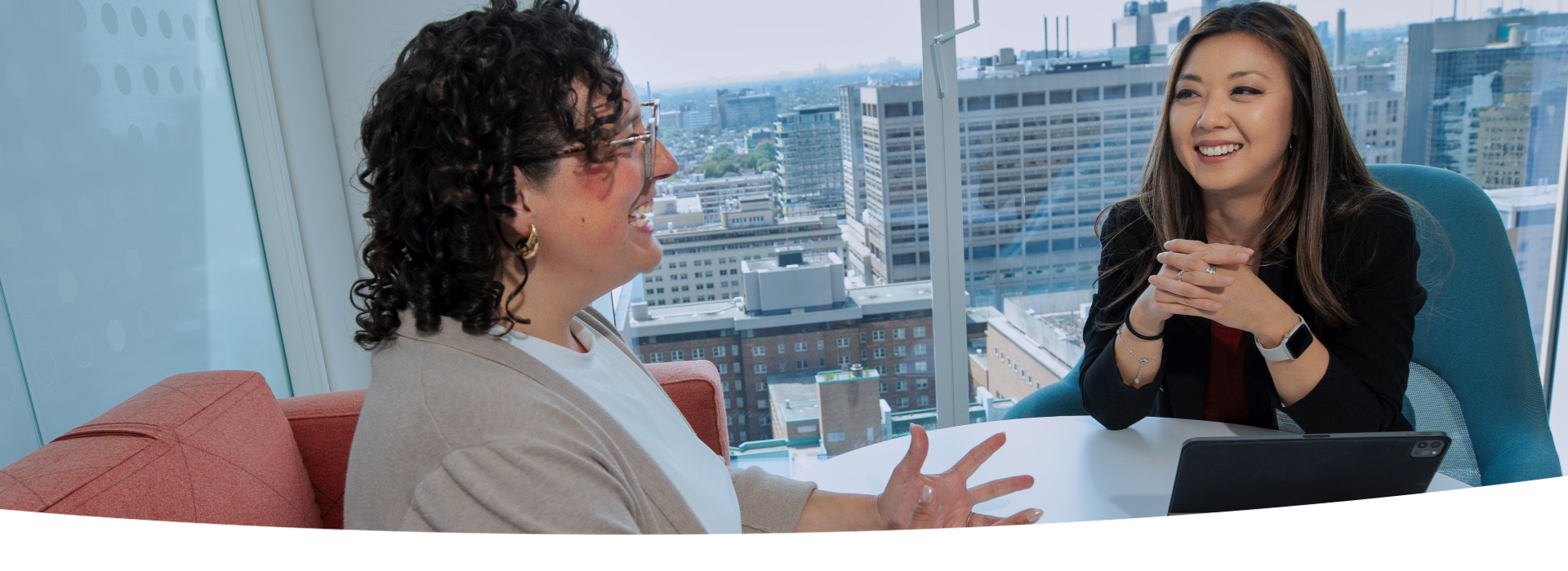 Two women seated at a table having a conversation.