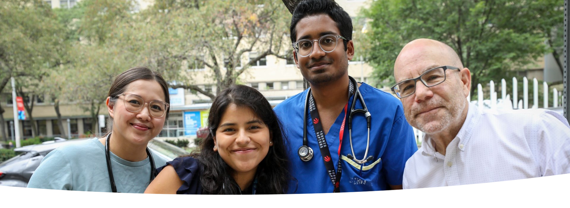 Four staff members together, outside.