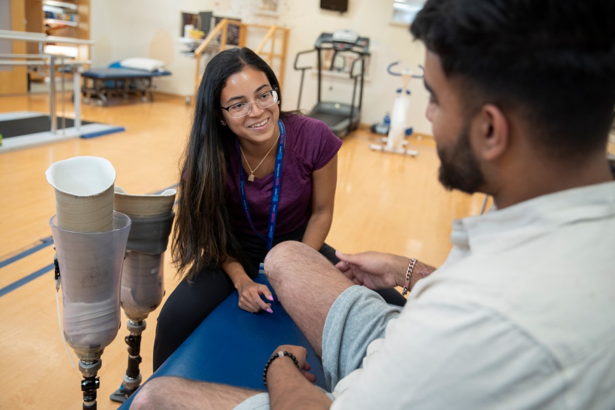 Staff member works with a patient in a physio gym.