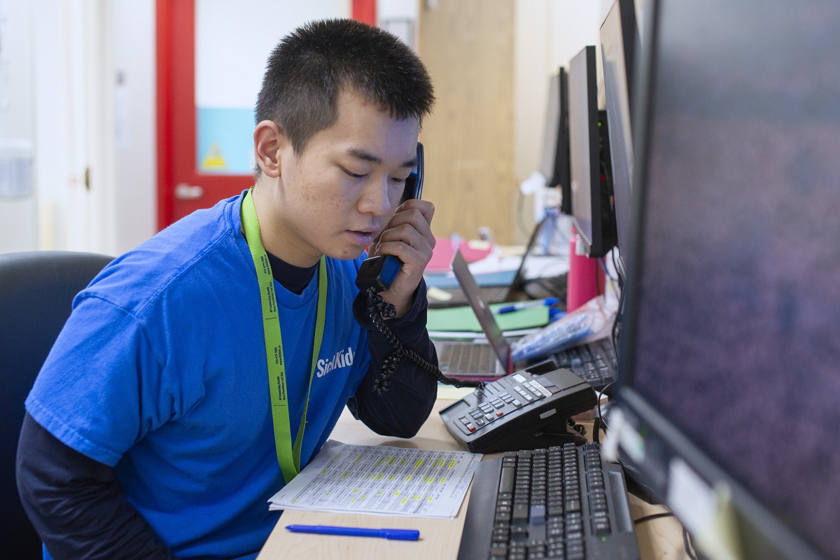Man seated at a desk, talking on the phone.