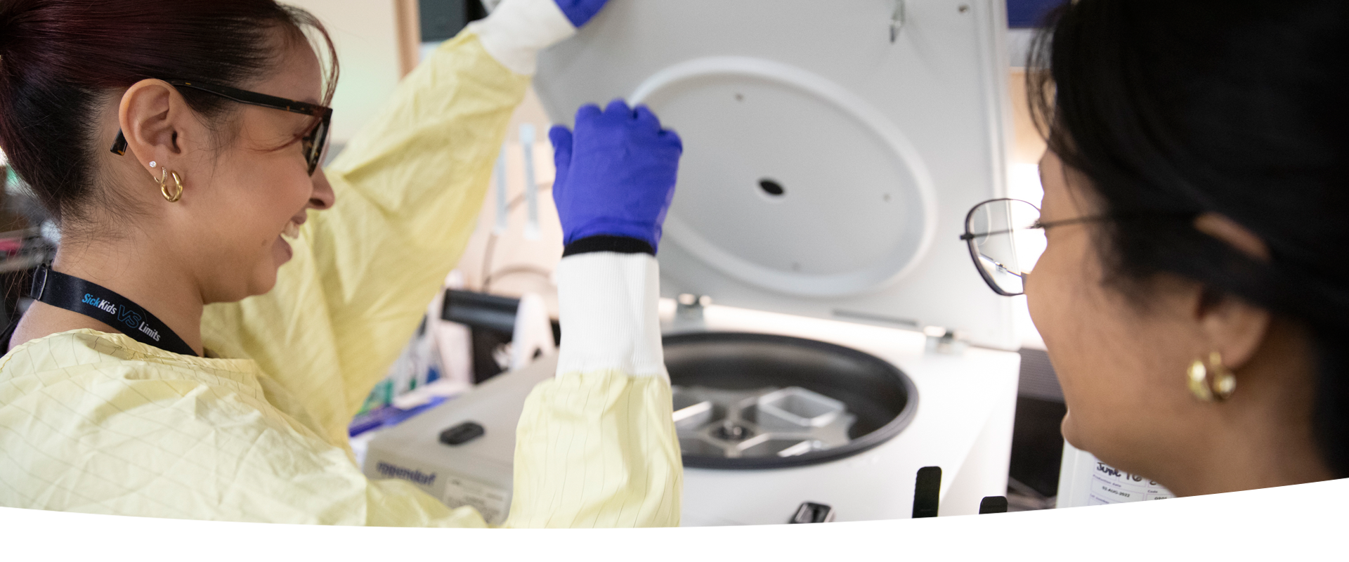 Two people use lab equipment.