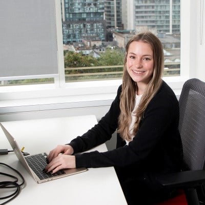 Volunteer seated at a desk with a laptop.