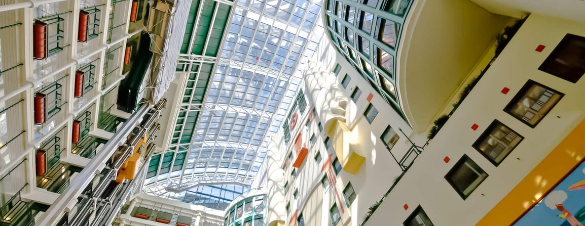 View looking up from the atrium with colourful glass walls framing the way to the roof