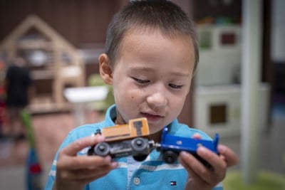 Boy plays with a toy train.