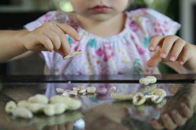 A young girl eating peanuts.