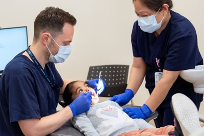 Dentist and dental hygienist examining a child's teeth