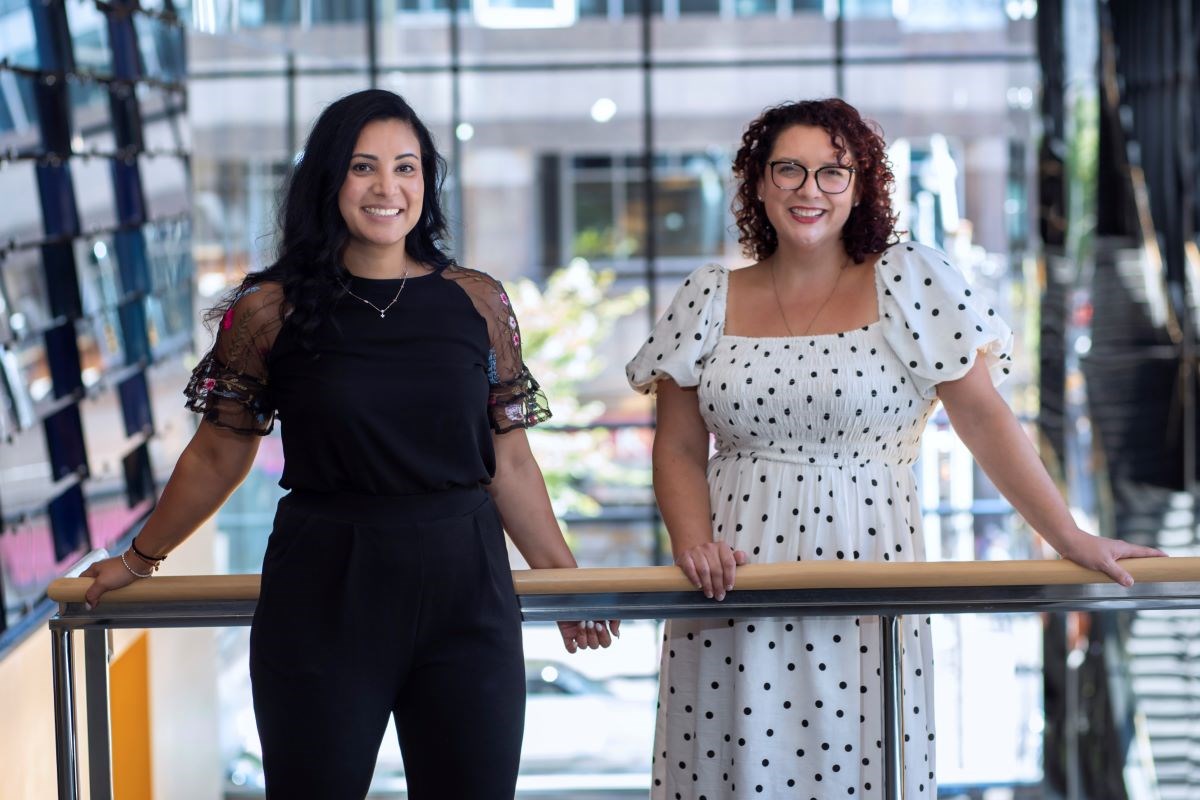 Registered Nurses' Council Co-chairs Katherine Andrews and Gina Driedger stand together leaning on a banister in front of a window.