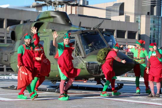 Men dressed as elves walk out of the Canadian Armed Forces Helicopter