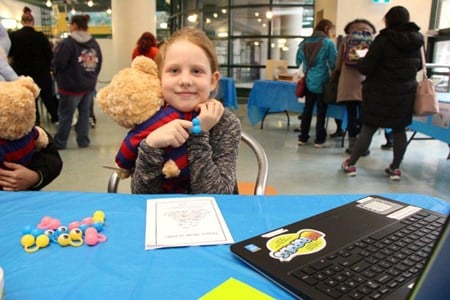 A young girl hugging a teddy bear