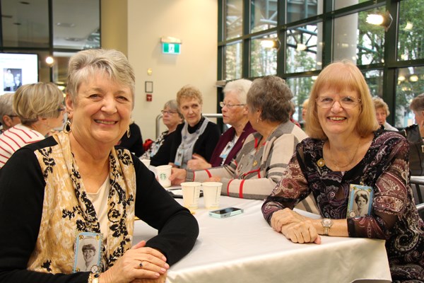 Two women sit together at a table.