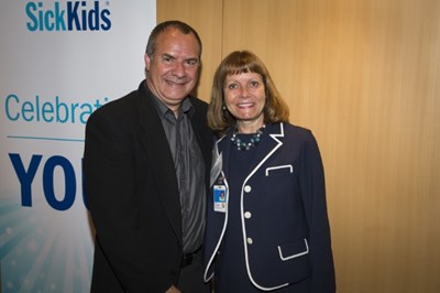 Formally dressed man and woman stand side by side.