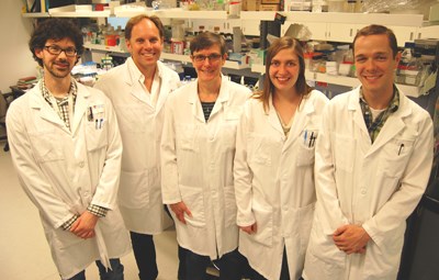 Team of five researchers in lab coats.