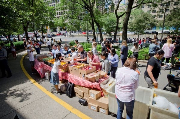 People line up at a row of tables outside SickKids.