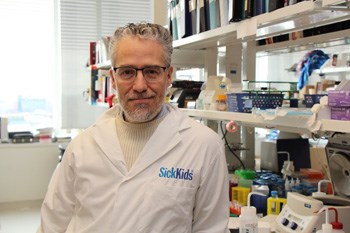 Person wearing lab coat stands in a lab.