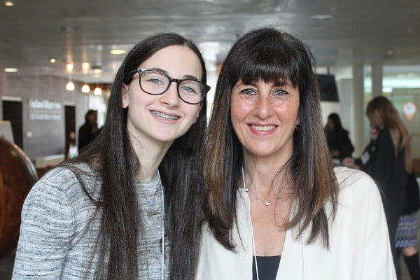 Teenage girl and her mom smile for the camera.