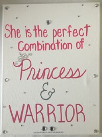 Whiteboard with pink writing that reads: She is the perfect combination of princess and warrior.