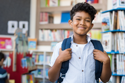 Boy in a classroom with a backpack