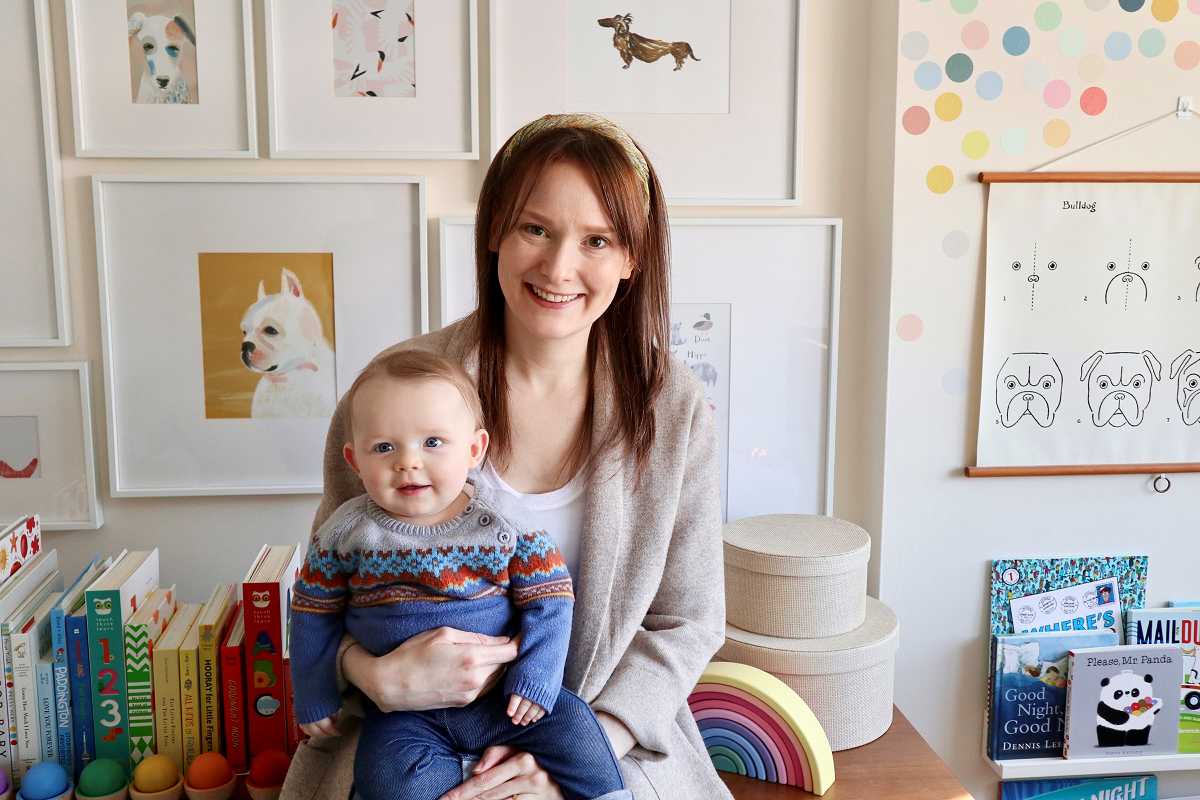 Seated woman holds baby.