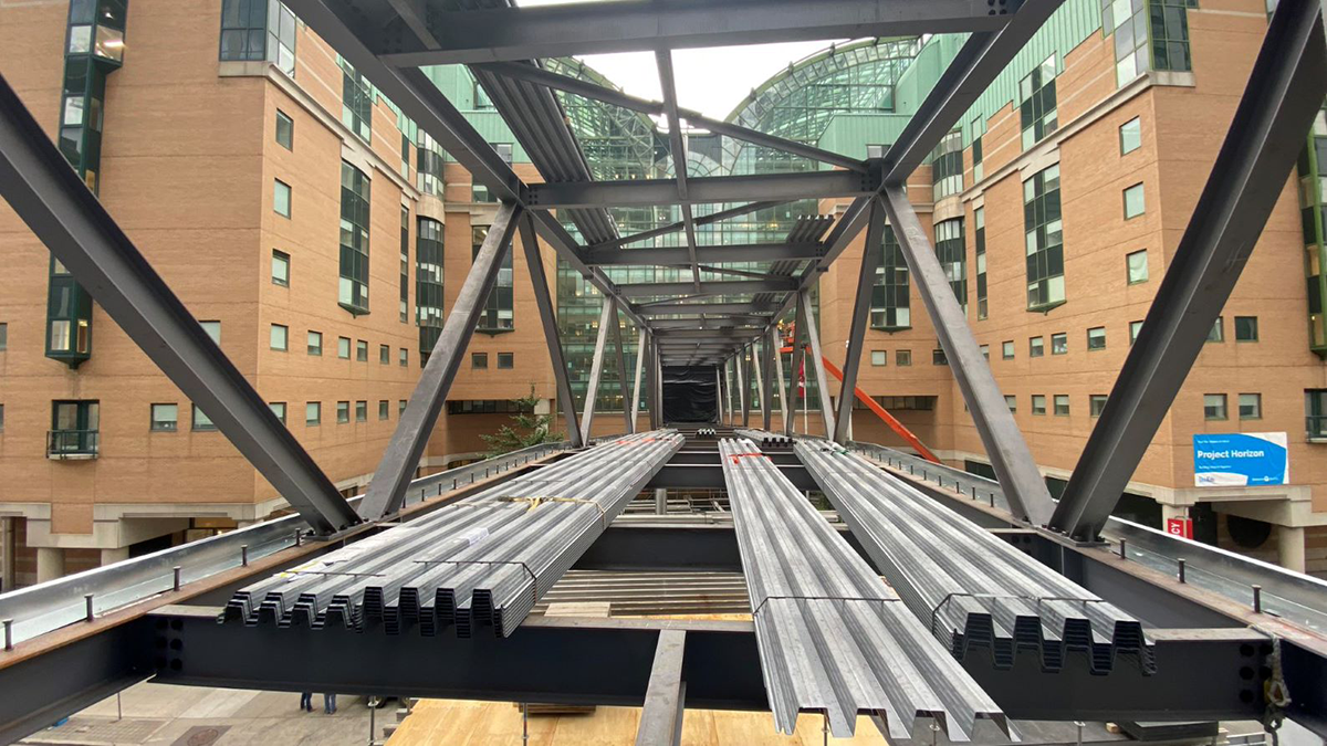 A structure made of steel beams that connects to a large building on one end