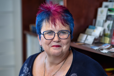 Person with colourful hair wearing glasses.