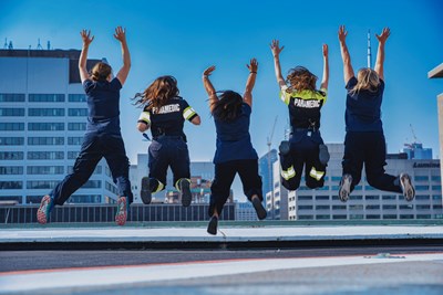 ACTS team members jumping in the air in unison on top of the SickKids helipad.