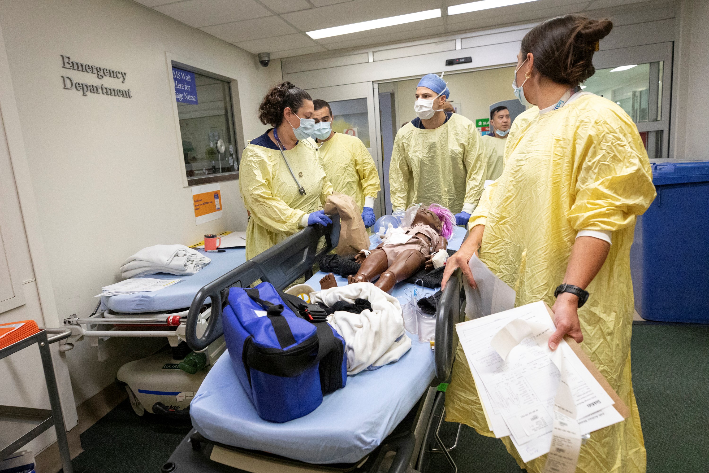 A full care team transports a simulated patient carefully to surgery on the second floor.