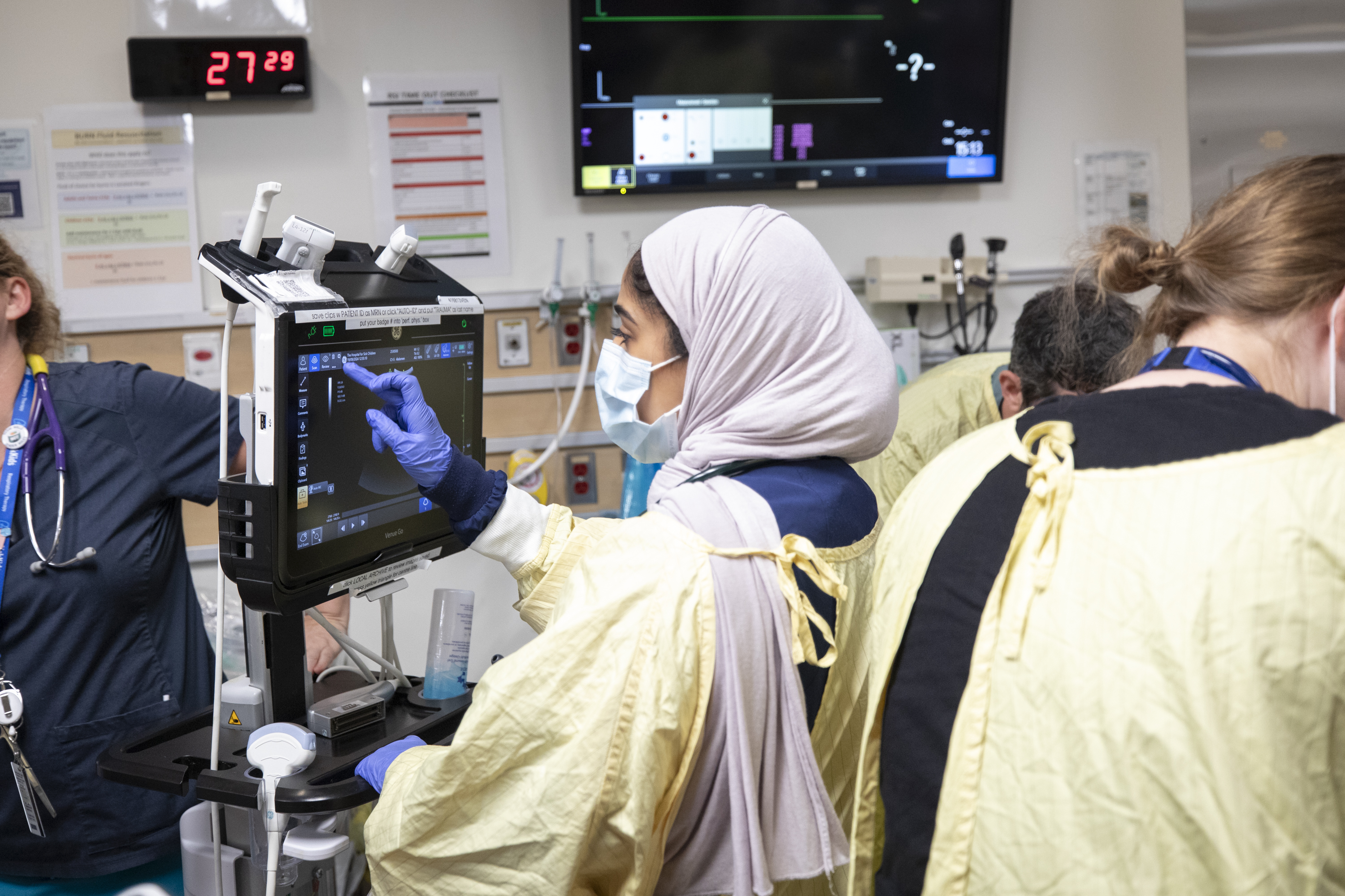 A physician examines an ultrasound for a simulated patient in the trauma room.