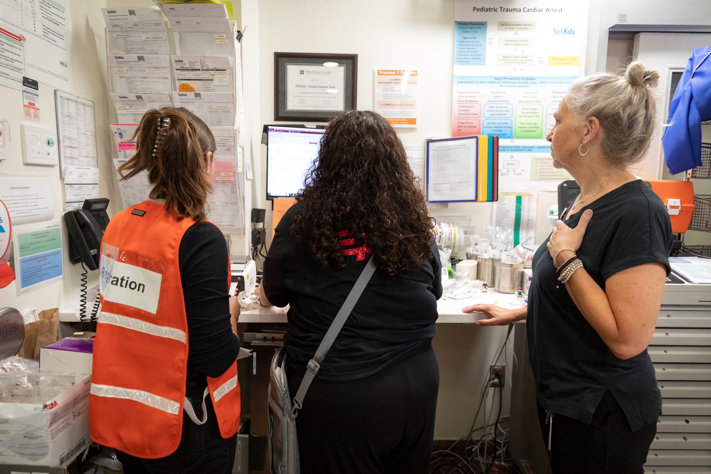 Andrea Boysen, right, and other staff work at a computer station to register simulated patients as they arrive.