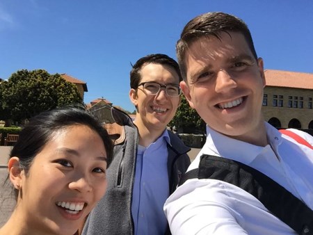 Jennifer Quon smiling and posing for a photo with two people.