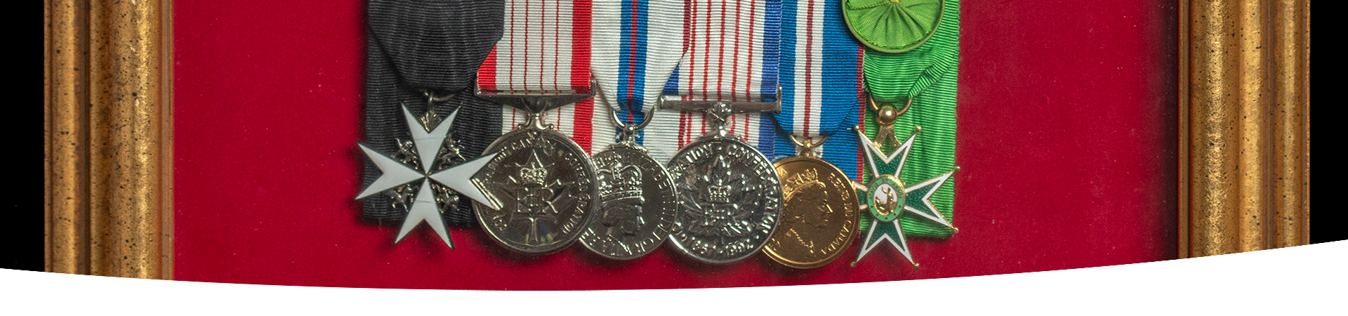 A close-up of a set of medals displayed in a picture frame.