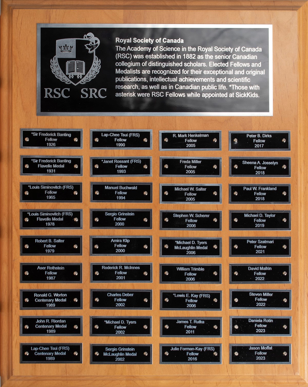 A wooden plaque with the names of RSC elected fellows and medalists engraved on black metal plating.