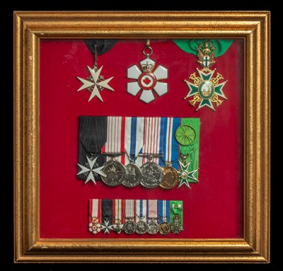 A variety of medals displayed inside a picture frame.
