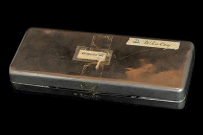 A closed rectangular metal box with a piece of tape labelled "Dr. Whaley".
